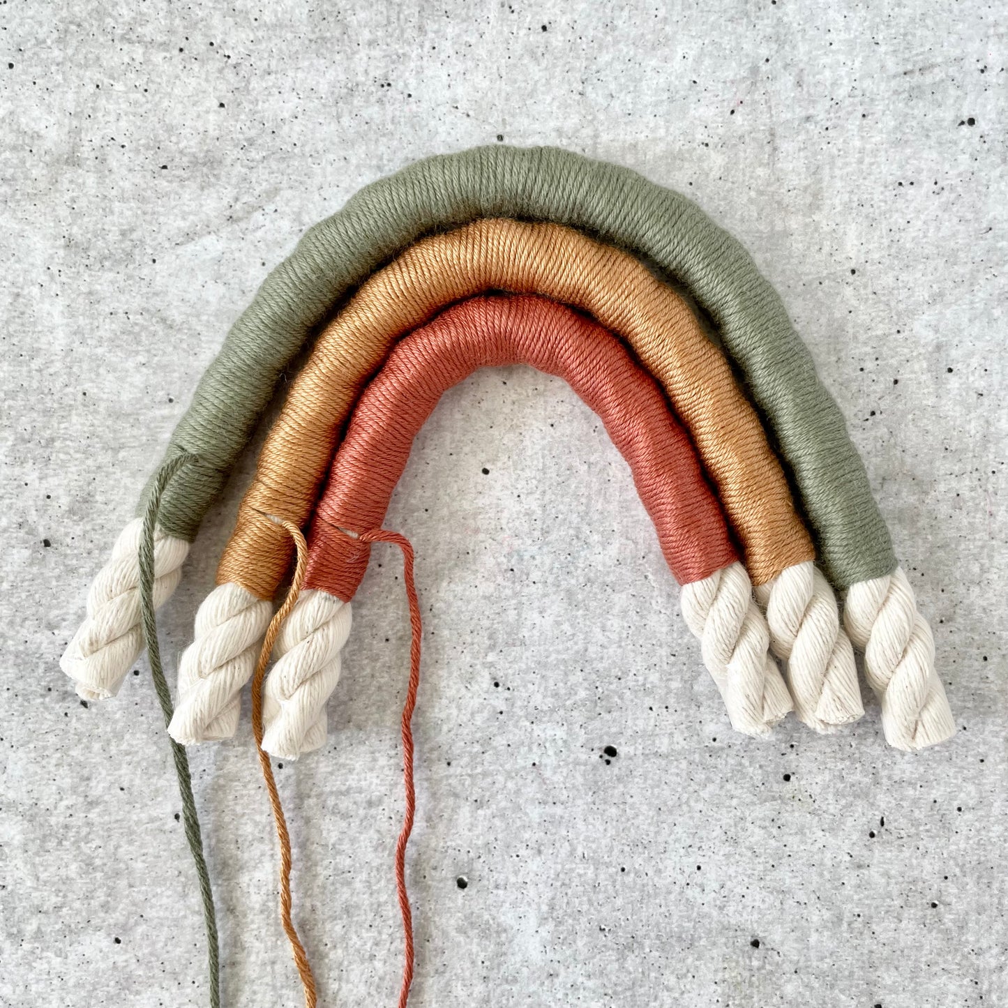 Detailaufnahme - bunte Regenbogen-Girlande aus Wolle mit Bommeln – DIY Kit für Boho Fans