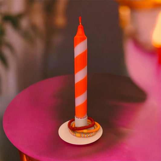 Detailaufnahme Dip Dye Kerze Neonorange-Rosa im Kerzenhalter auf pinkem Tisch