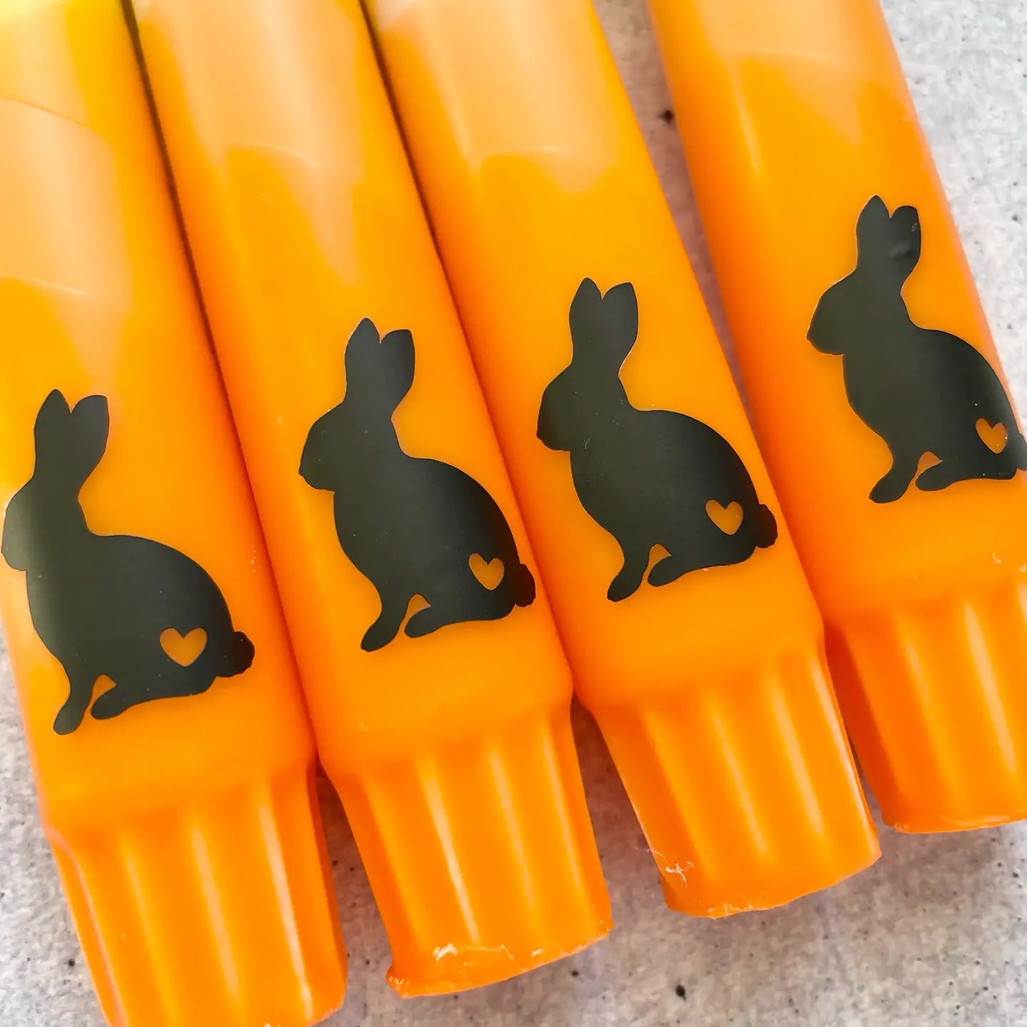 Orange-gelbe Osterkerze mit Hasenmotiv