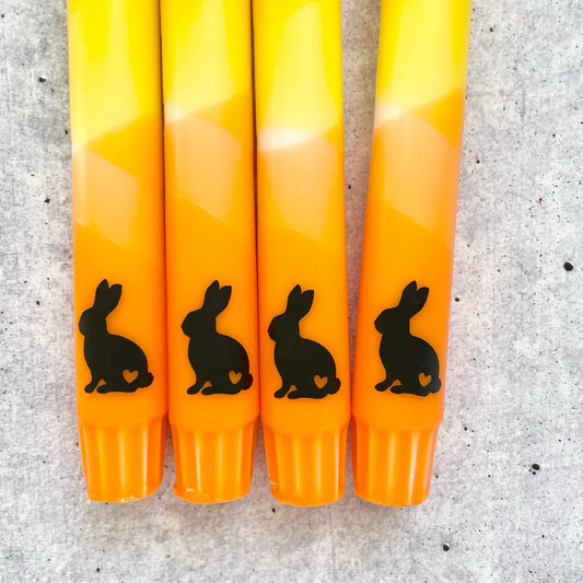 Osterkerze in warmen Orange- und Gelbtönen mit süßem Hasen