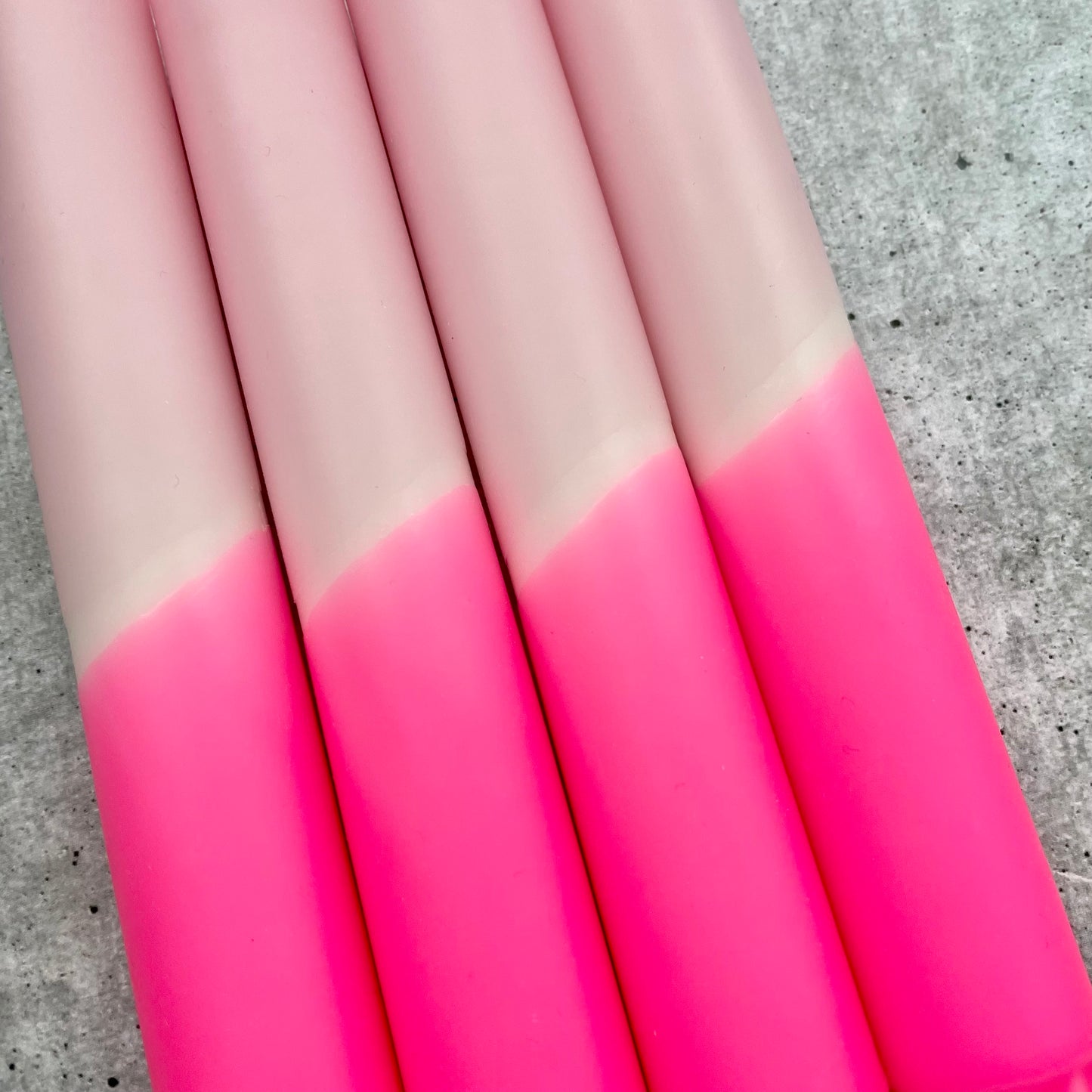 Nahaufnahme der Oberfläche einer Dip Dye Kerze in Neonpink und Rosa