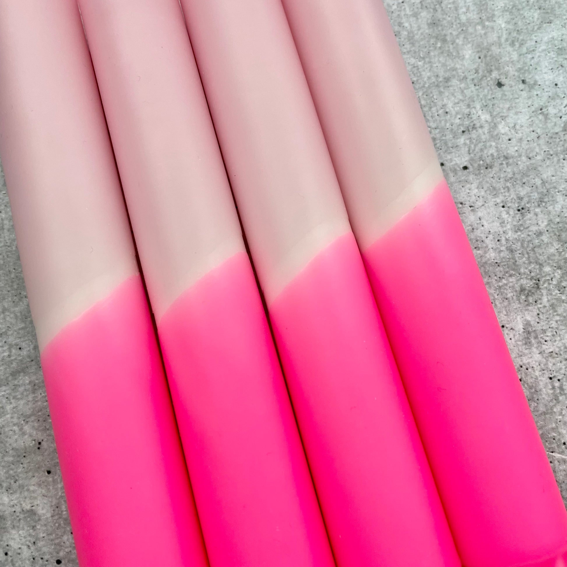 Nahaufnahme der Oberfläche einer Dip Dye Kerze in Neonpink und Rosa