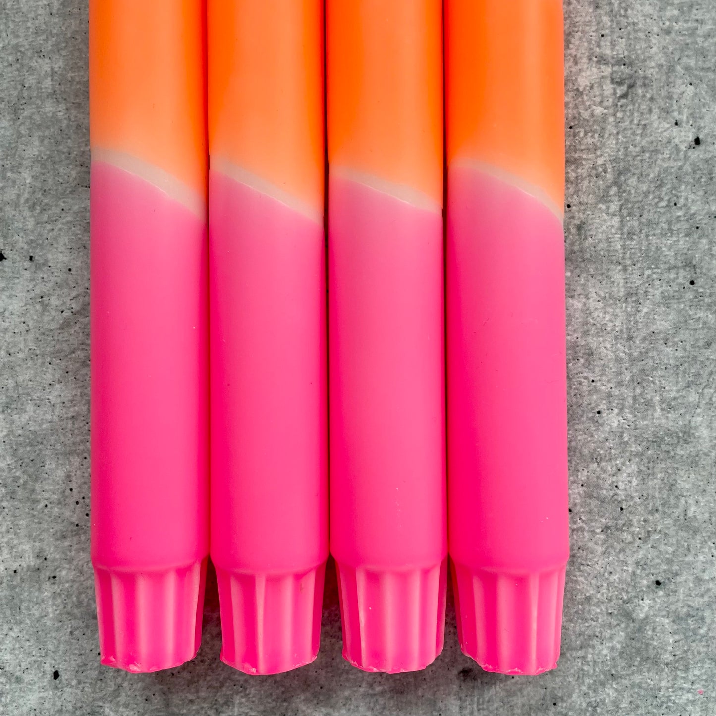 Detailaufnahme einer Dip Dye Stabkerze - lebhafter Farbverlauf in Neonpink und Neonorange