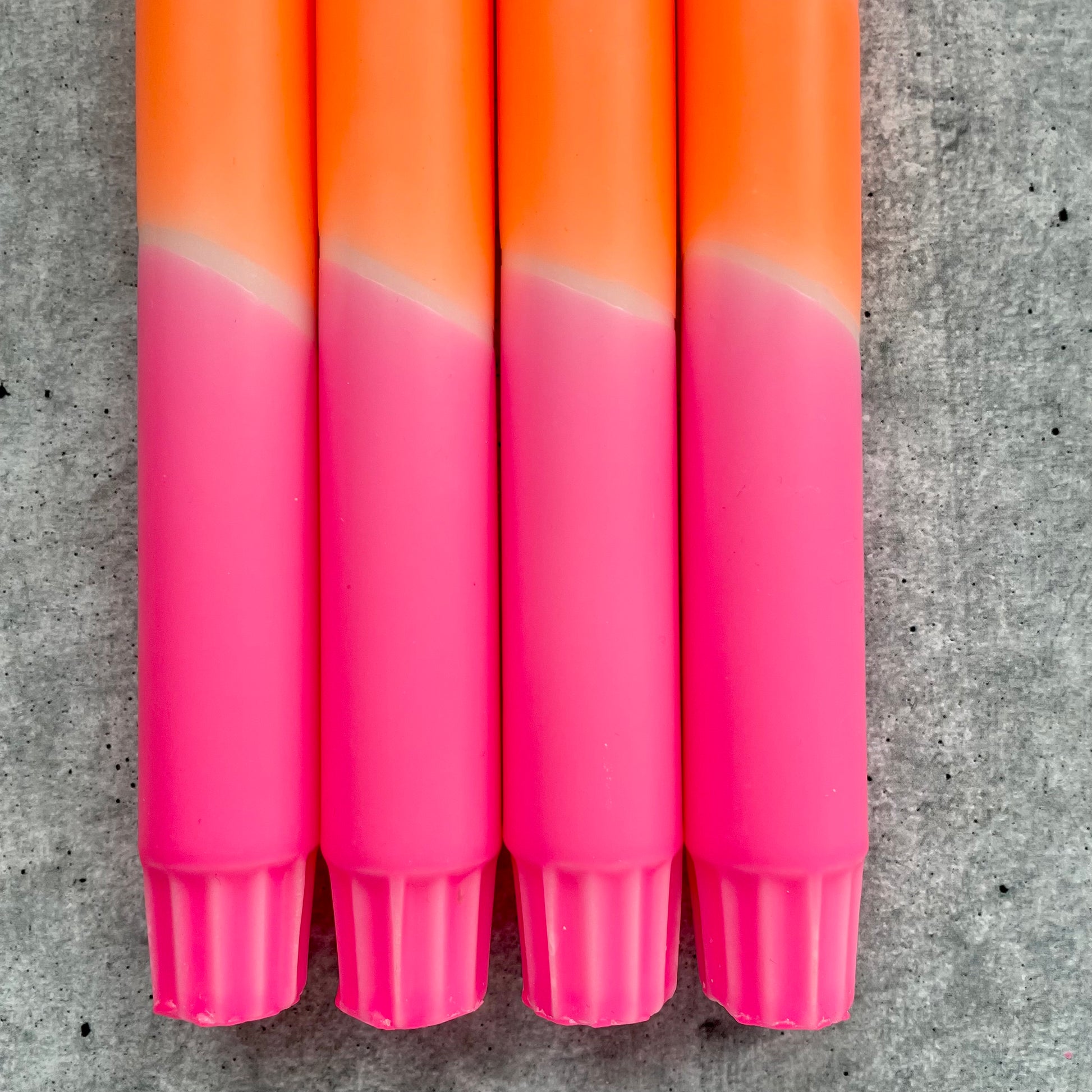 Detailaufnahme einer Dip Dye Stabkerze - lebhafter Farbverlauf in Neonpink und Neonorange