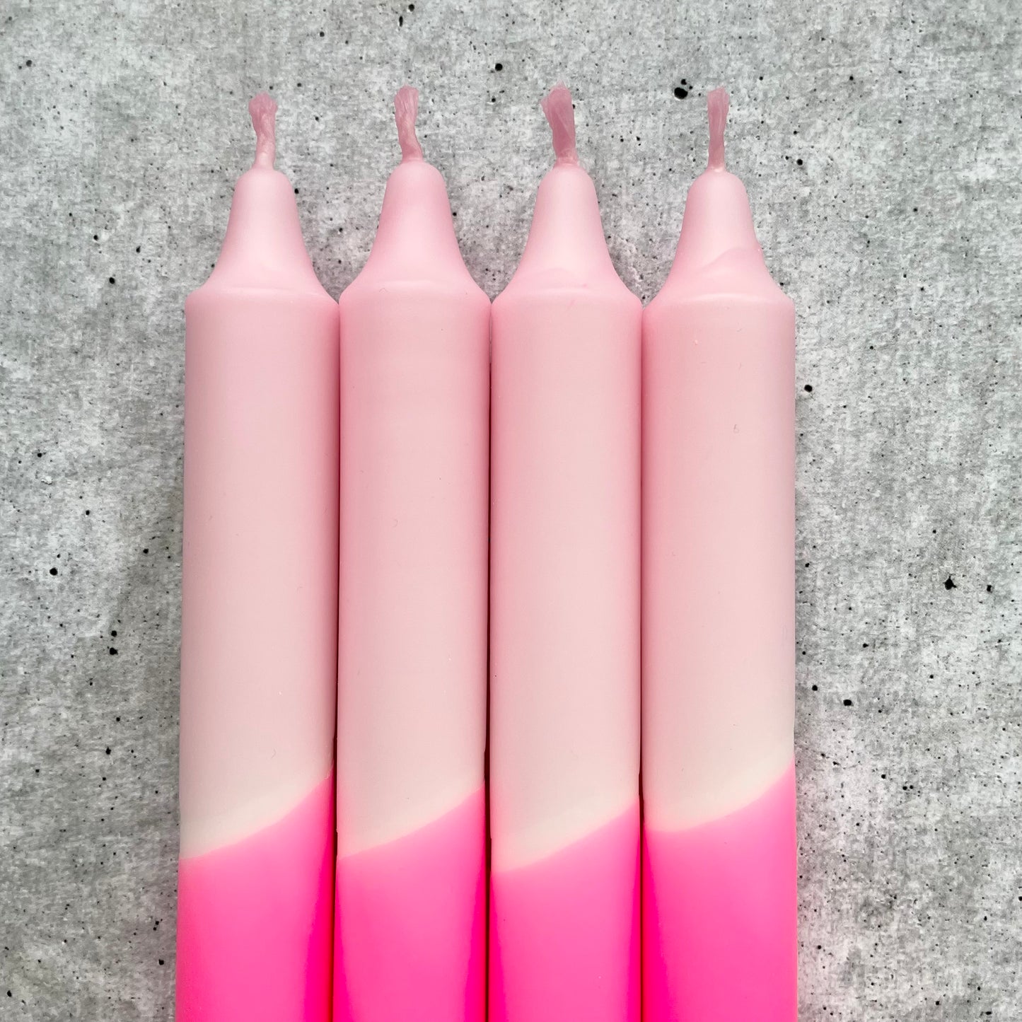 Detailaufnahme des lebhaften Farbverlaufs einer Dip Dye Kerze in Neonpink und Rosa