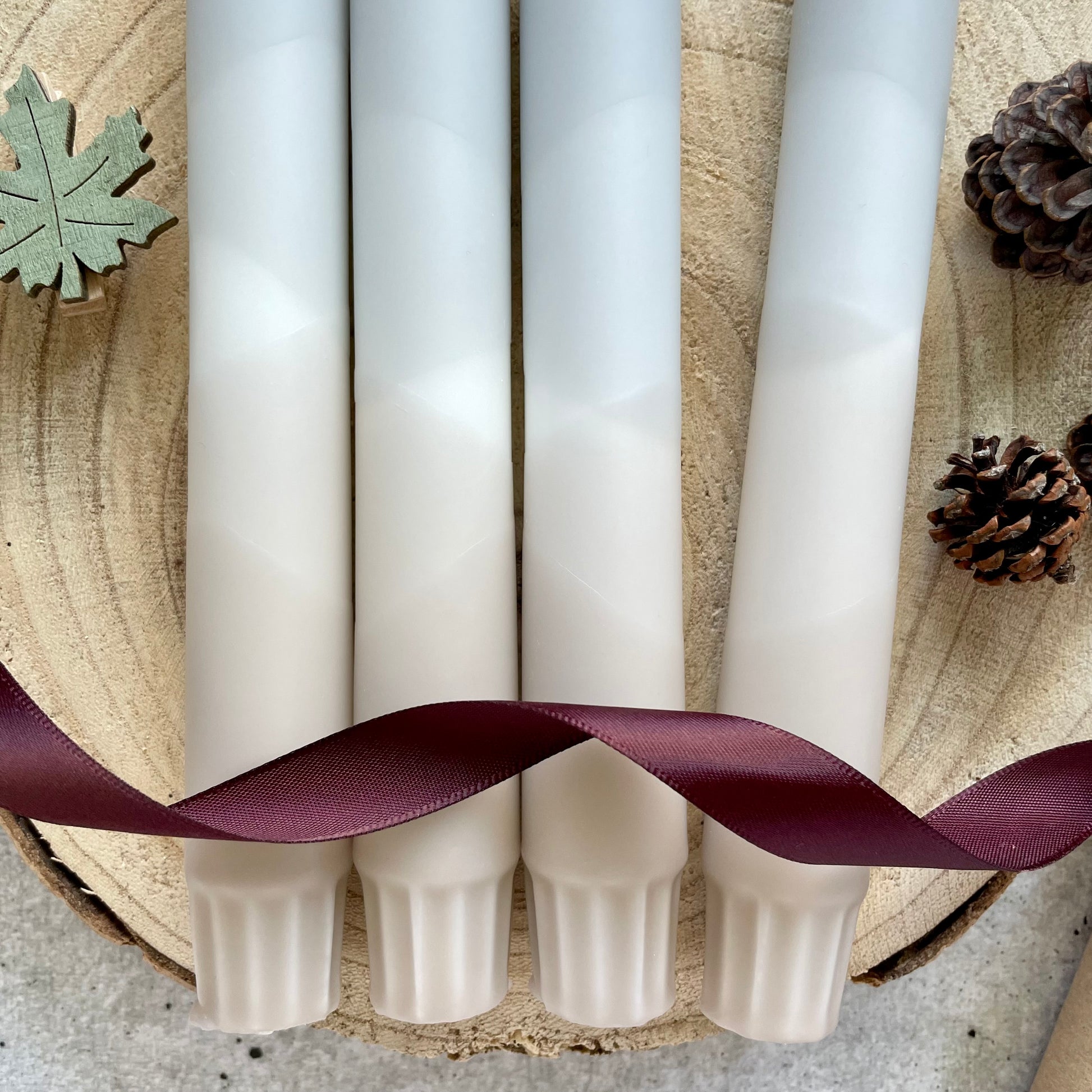 Nahaufnahme einer handgemachten Dip Dye Kerze in Beige und Grau