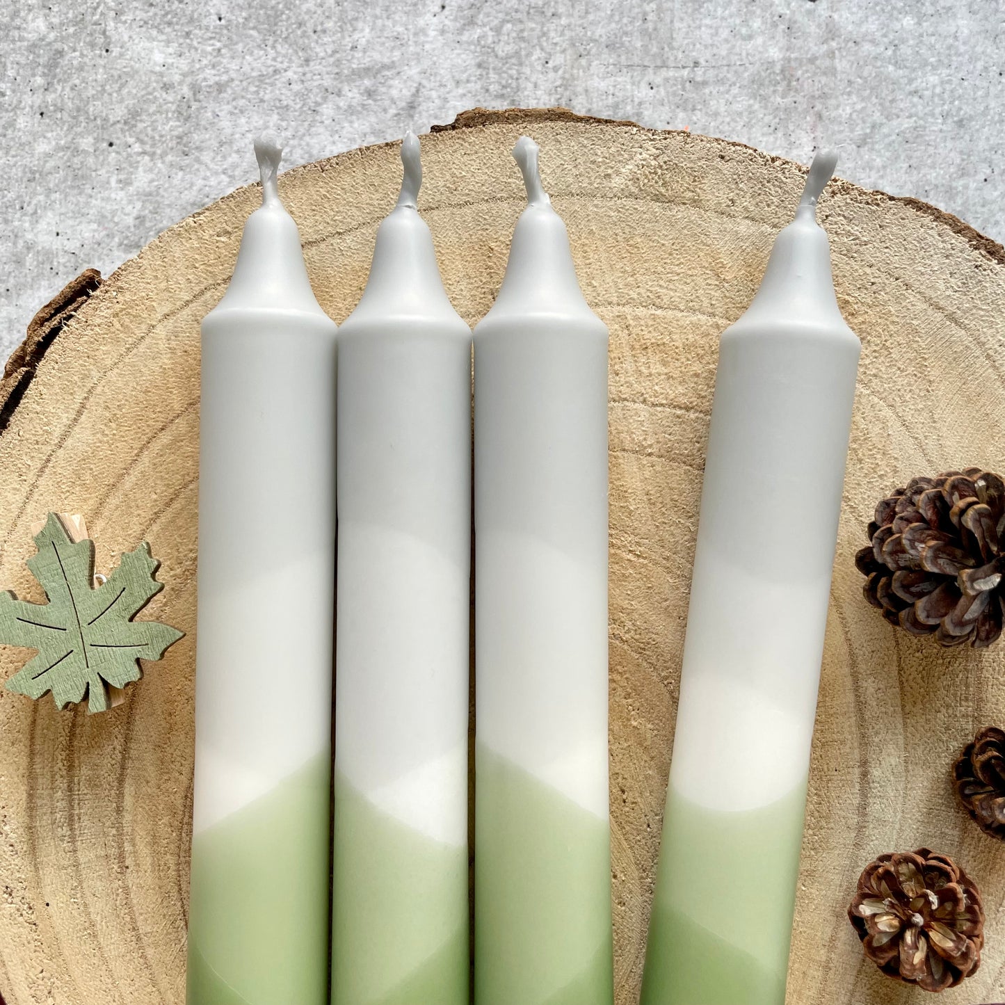 Nahaufnahme einer handgemachten Dip Dye Kerze in Olive und Grau