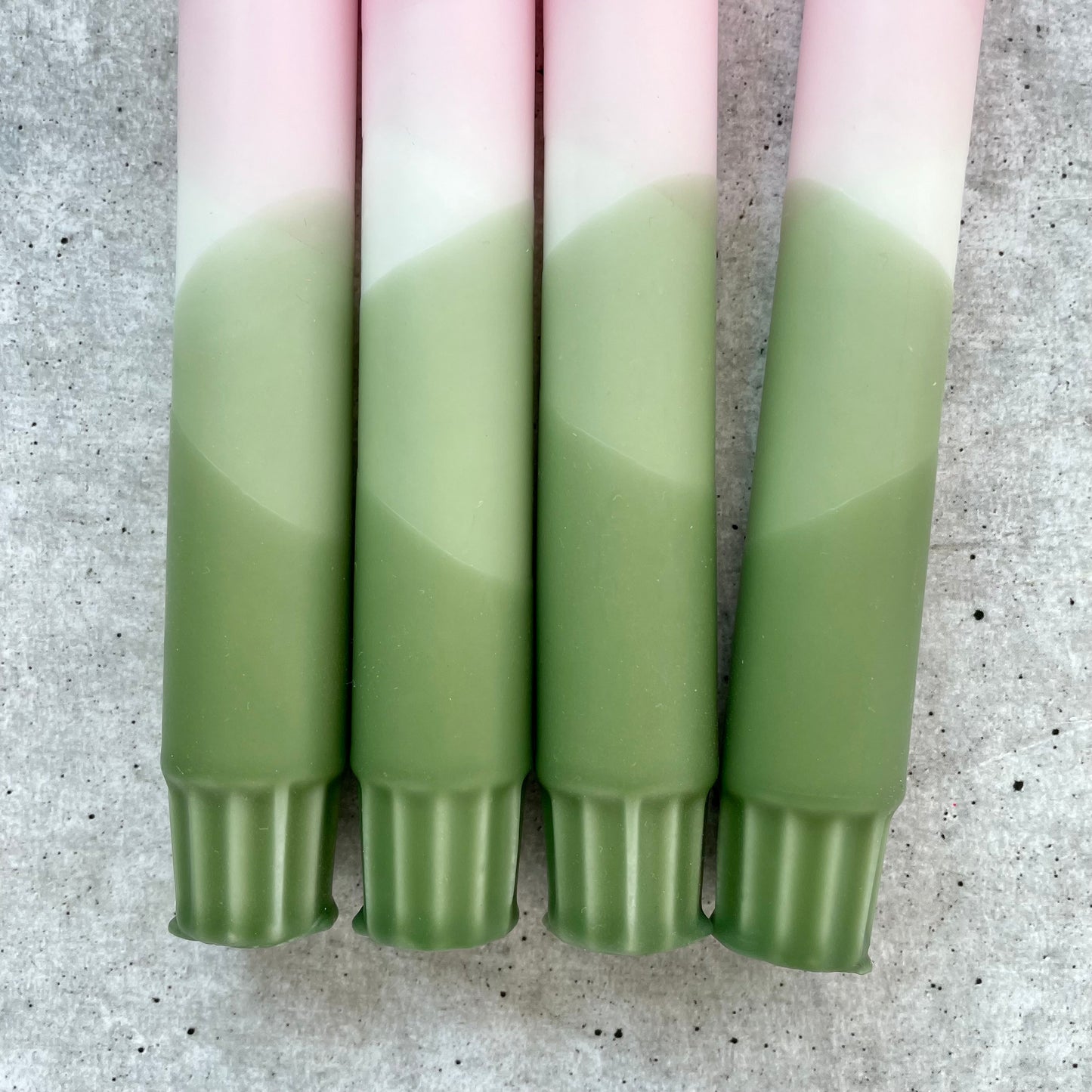 Nahaufnahme einer handgemachten Dip Dye Kerze in Olive und Rosa