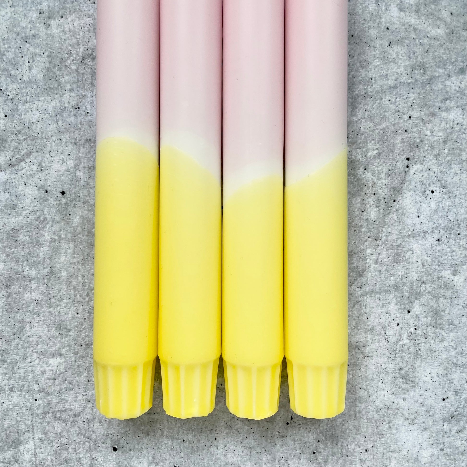 Nahaufnahme einer handgefertigten Dip Dye Kerze im Rosa‑Gelb Mix