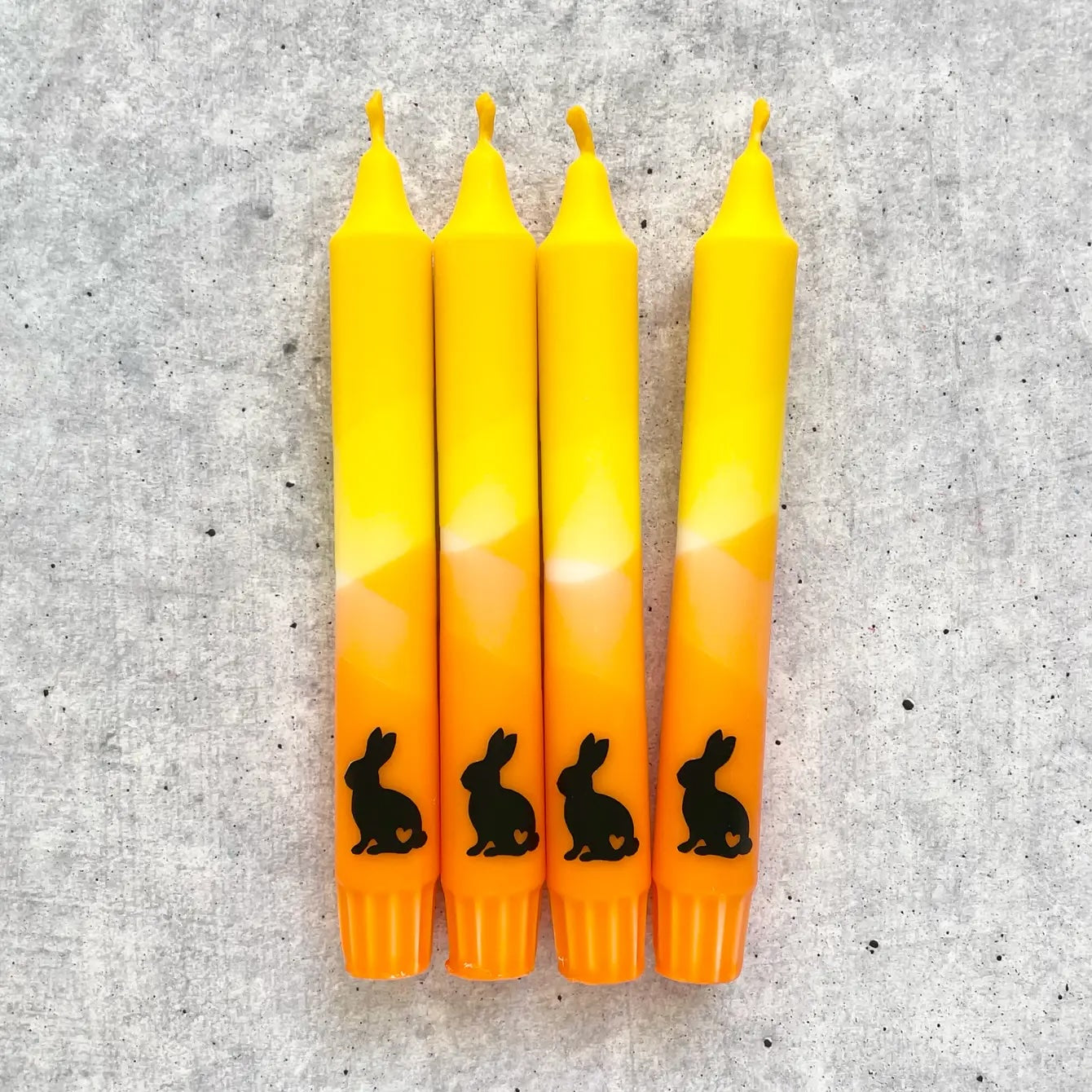 Fröhliche Osterkerze in Orange und Gelb für Tischdekoration