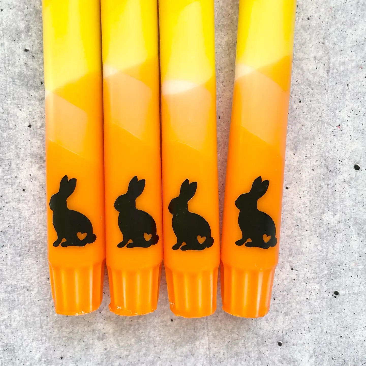 Osterkerze in warmen Orange- und Gelbtönen mit süßem Hasen